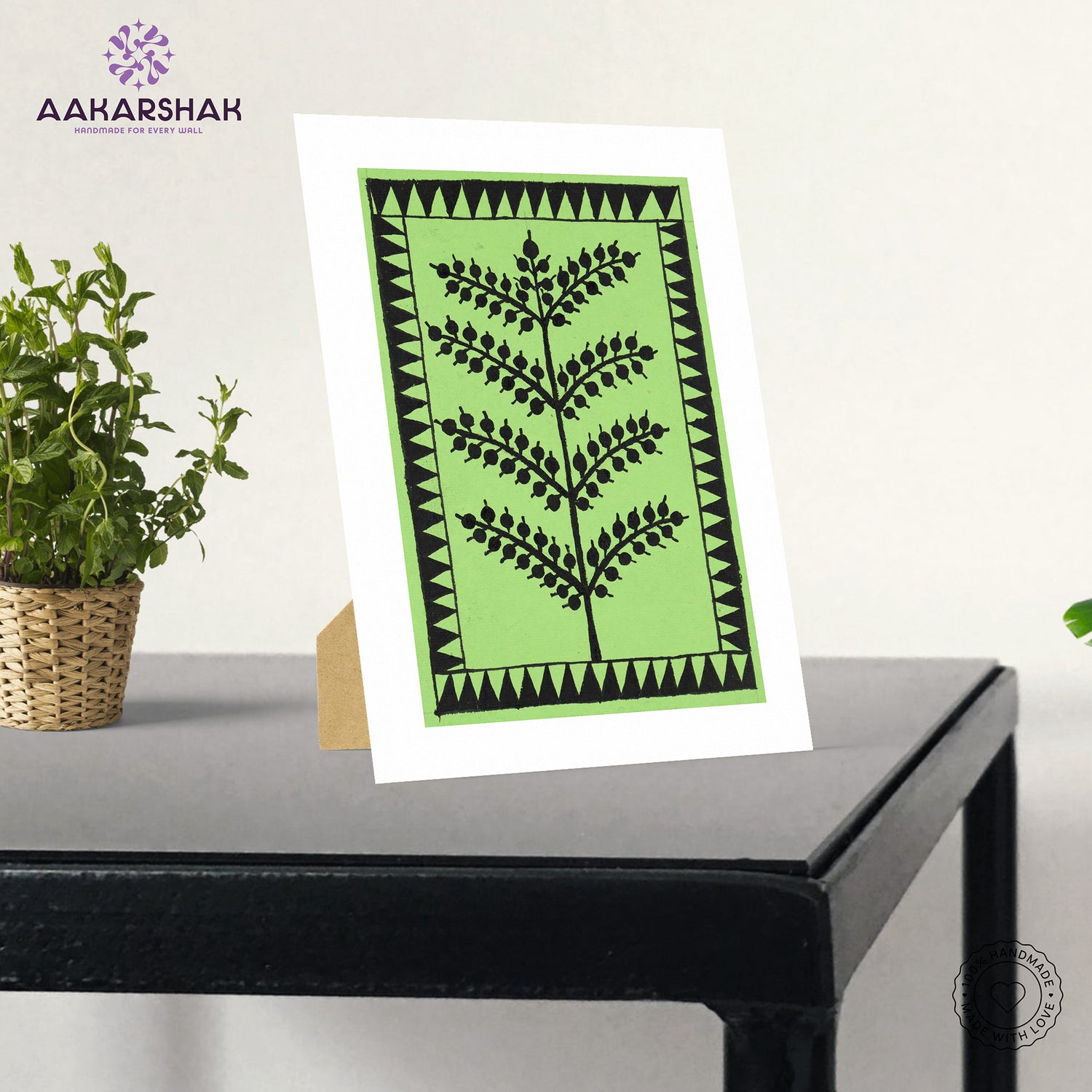Framed artwork with green background and black tree warli painting