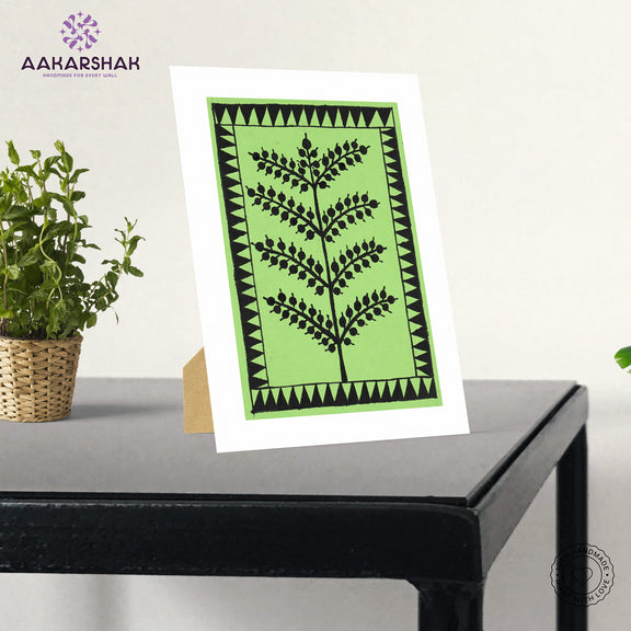 Framed artwork with green background and black tree warli painting
